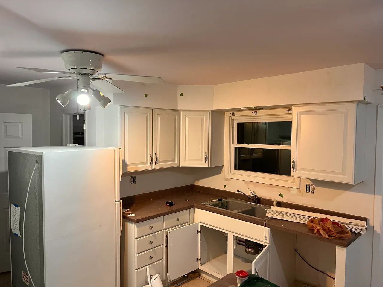 Kitchen renovation with white cabinets and ceiling fan. Skilled ceiling fan and light installation and home remodeling.