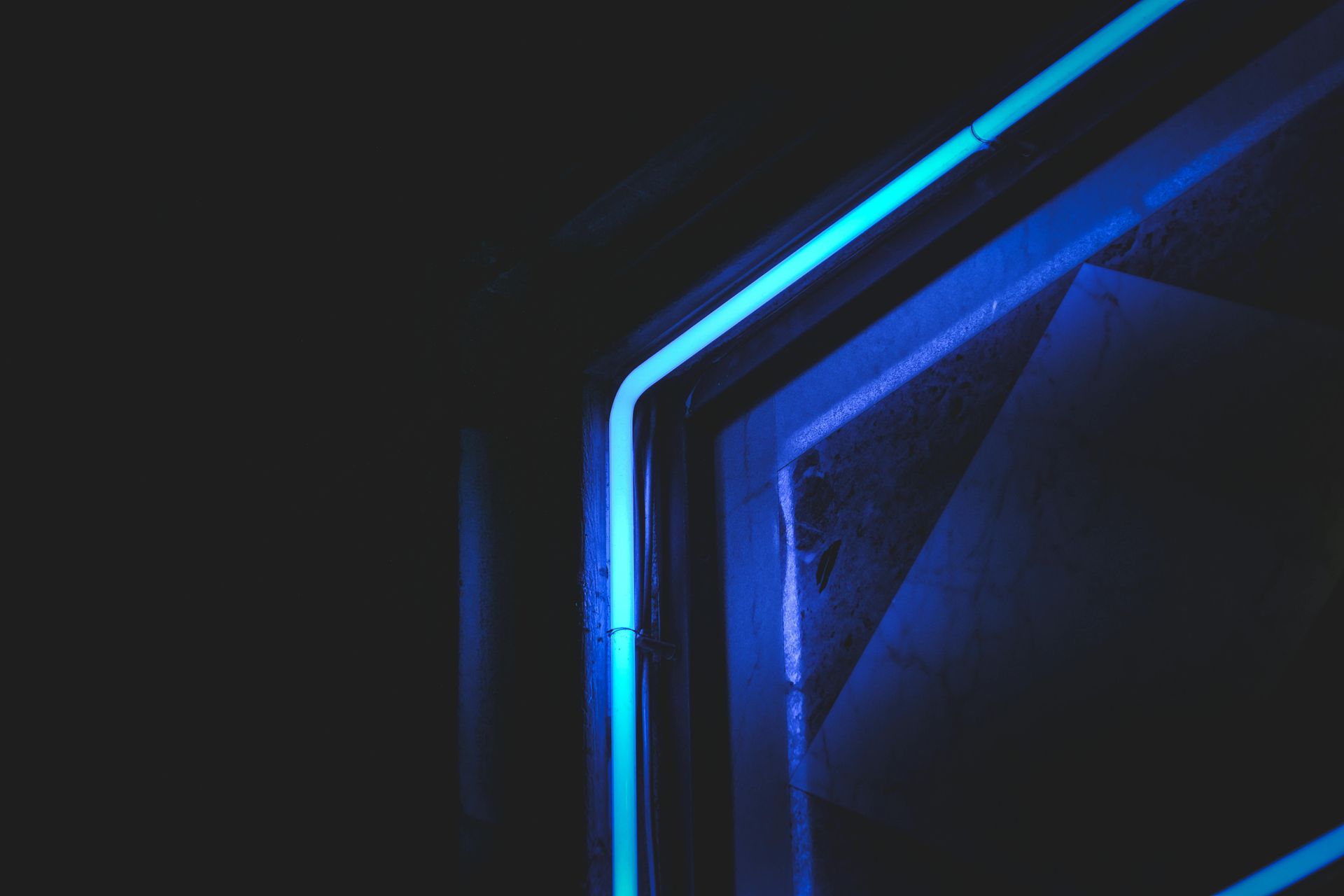 A blue light is shining on a dark background.