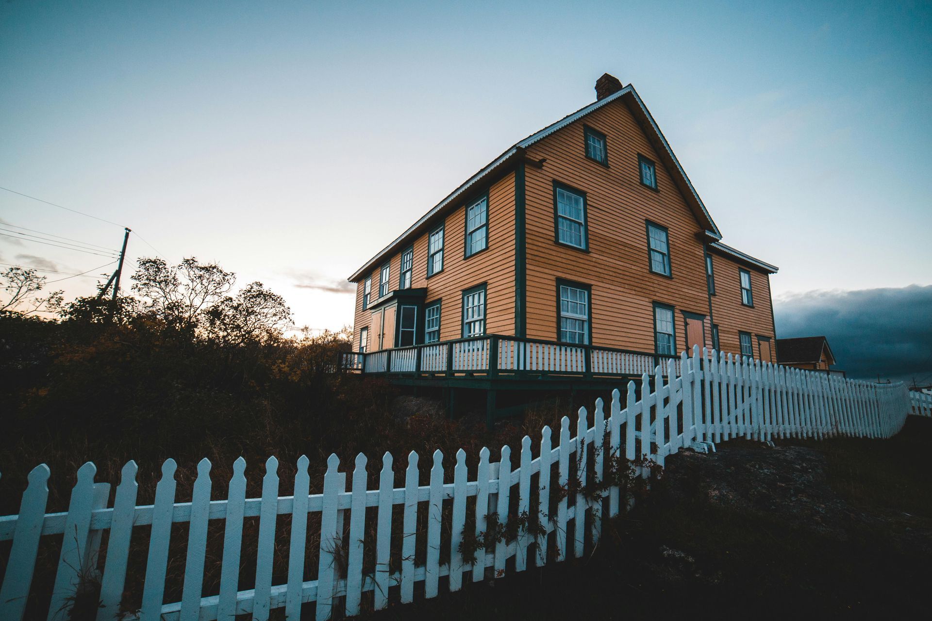 A large house with a white picket fence in front of it.