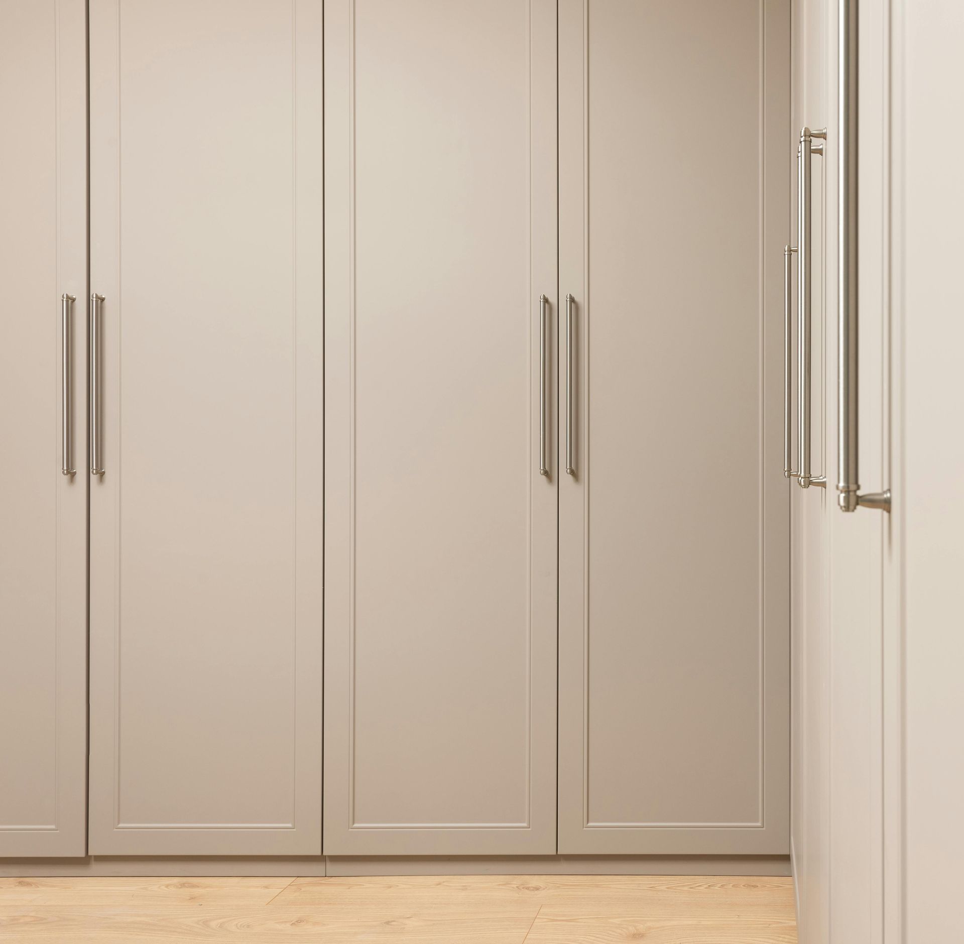 A kitchen with white cabinets and a wooden floor.