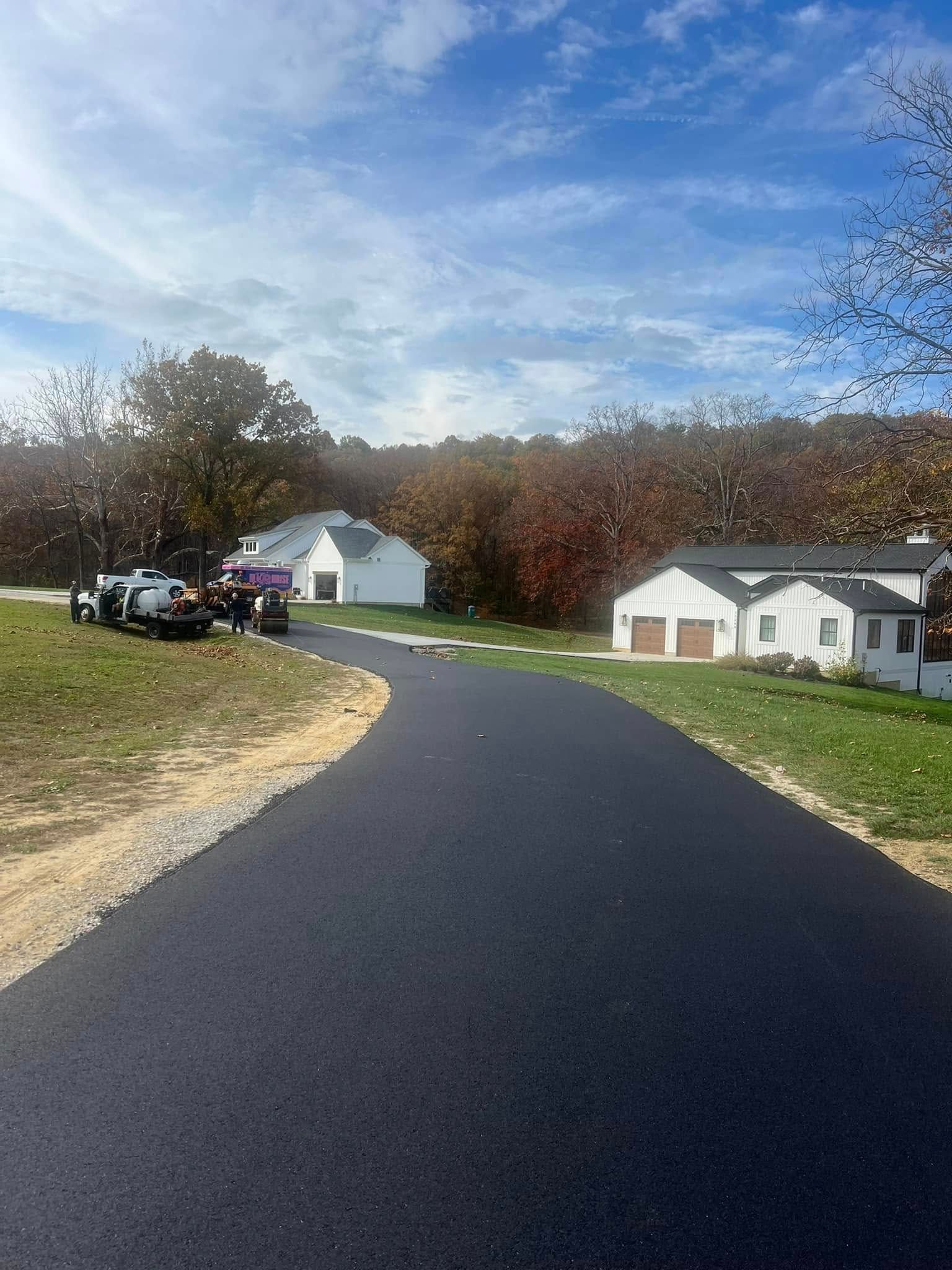 A road with a lot of cars parked on the side of it in a residential area.