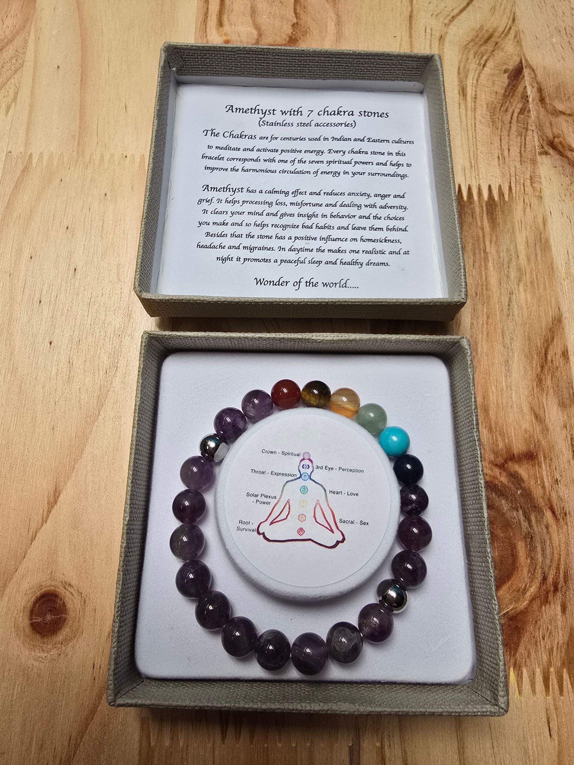 Een armband ligt in een doos op een houten tafel