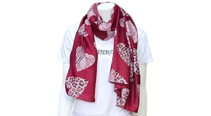 Mannequin met een rode sjaal met hartjespatroon, een wit T-shirt en een witte broek, afgebeeld tegen een witte achtergrond.