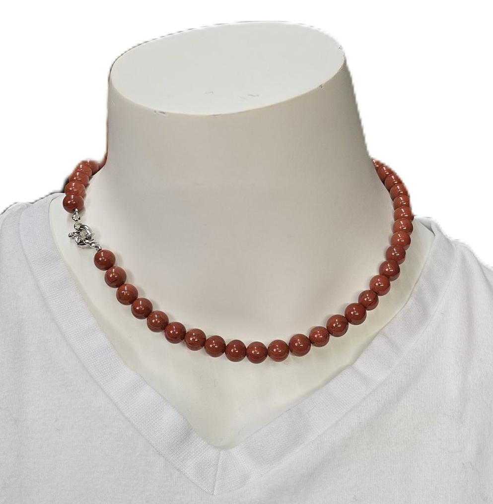 Een ketting van turkooizen kralen om de nek van een paspop, de sluiting is zichtbaar.