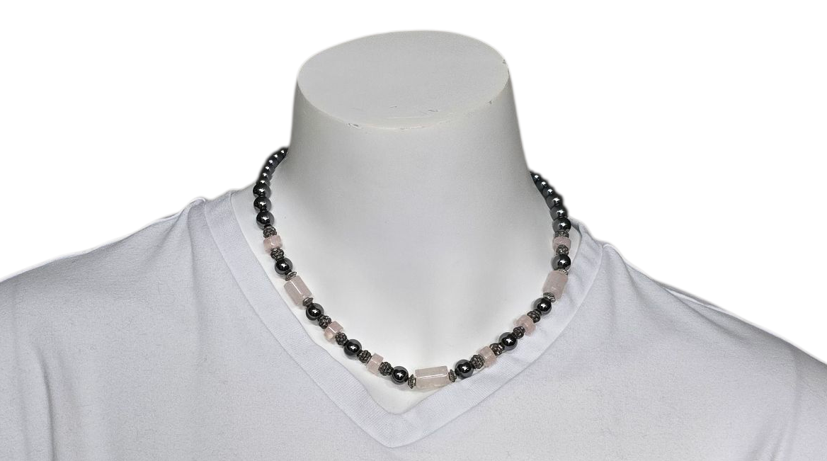 Een blauwe en grijze kralenketting op een wit T-shirt en de nek van een paspop.