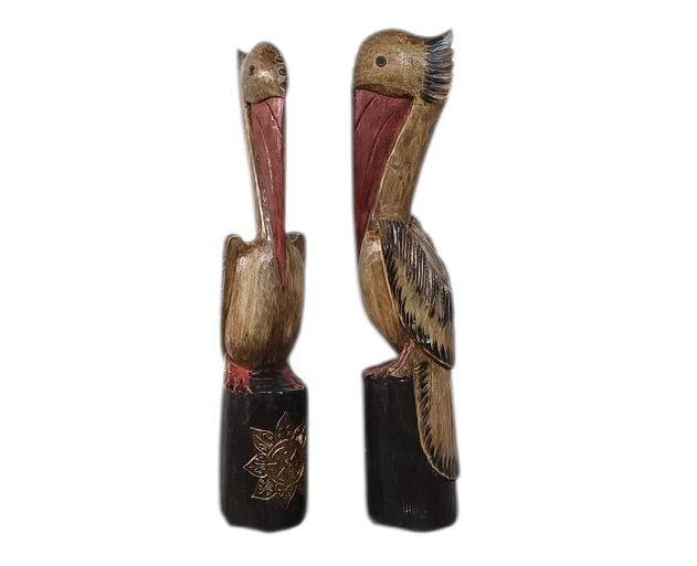 Twee uit hout gesneden pelikaanbeelden op zwarte sokkels.