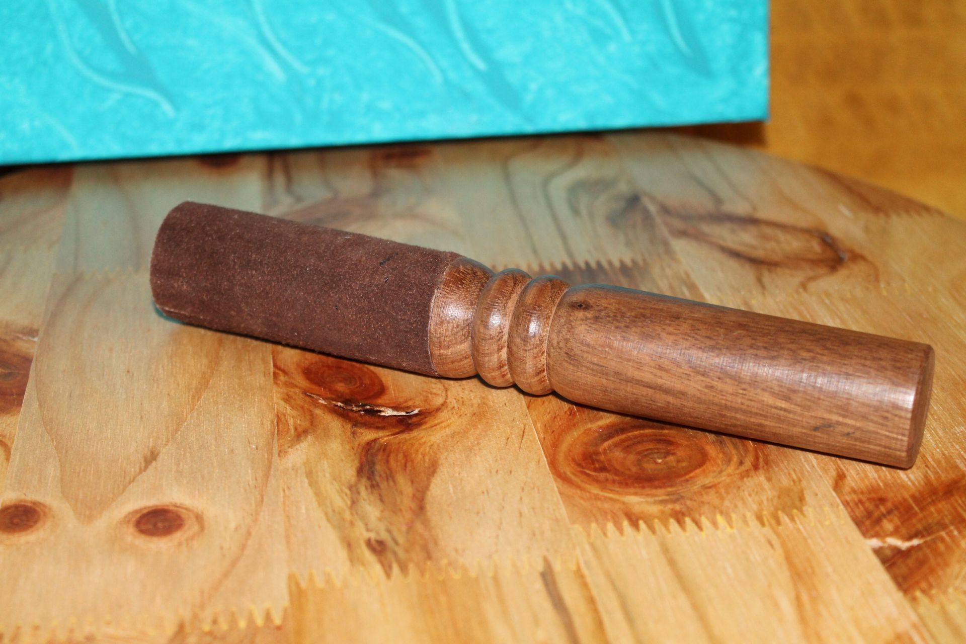 Een klein houten stokje ligt op een houten tafel.