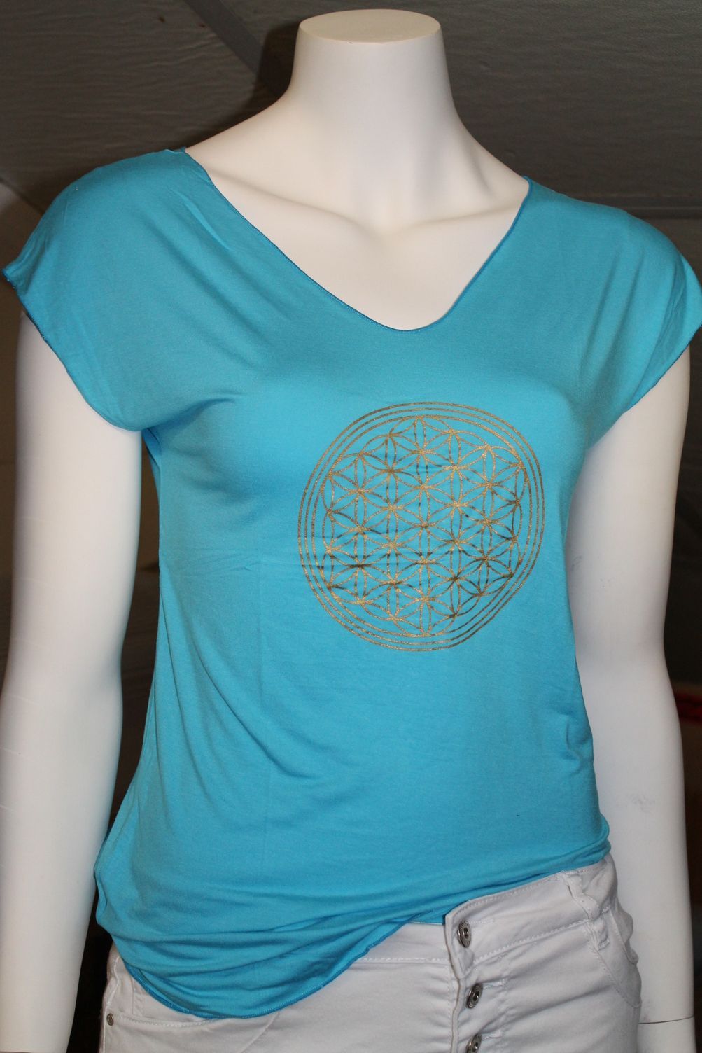 Rood T-shirt met gouden print van heilige geometrie op een paspop.
