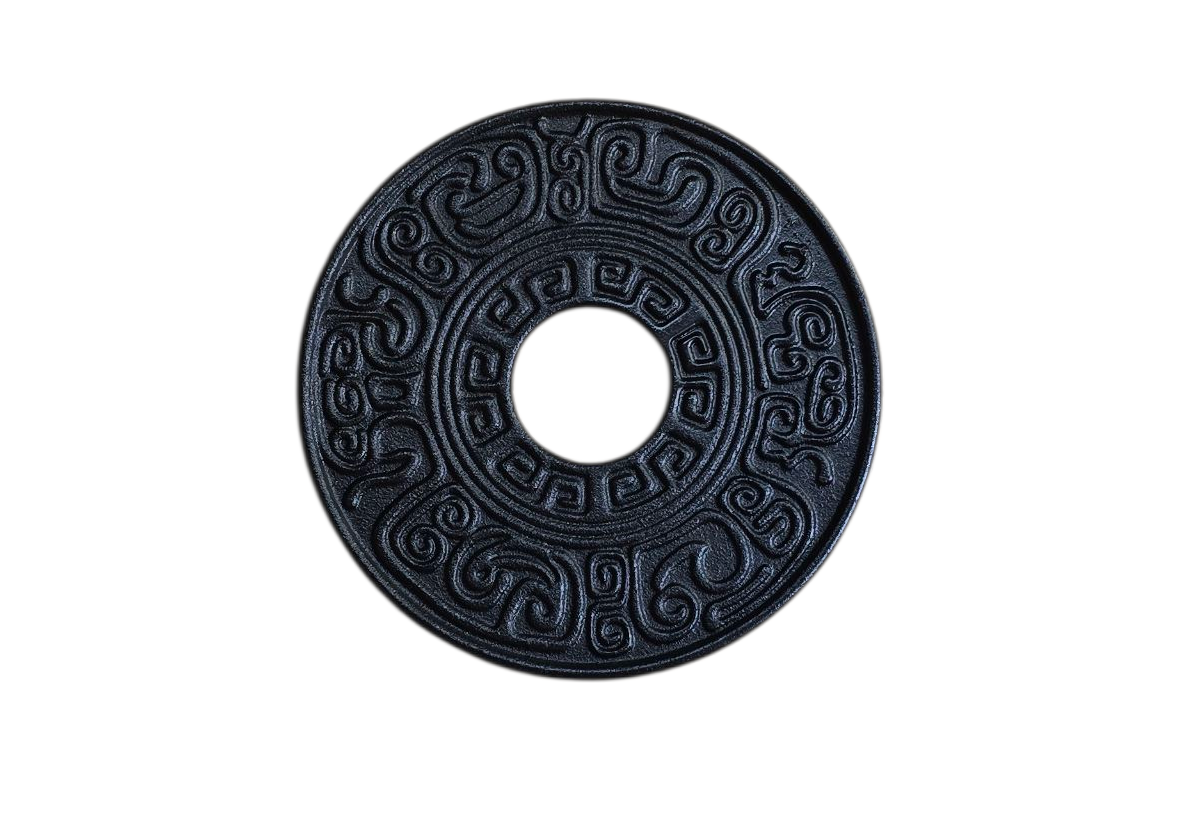 Zwarte, ronde munt met een gat in het midden en een sierlijk patroon.