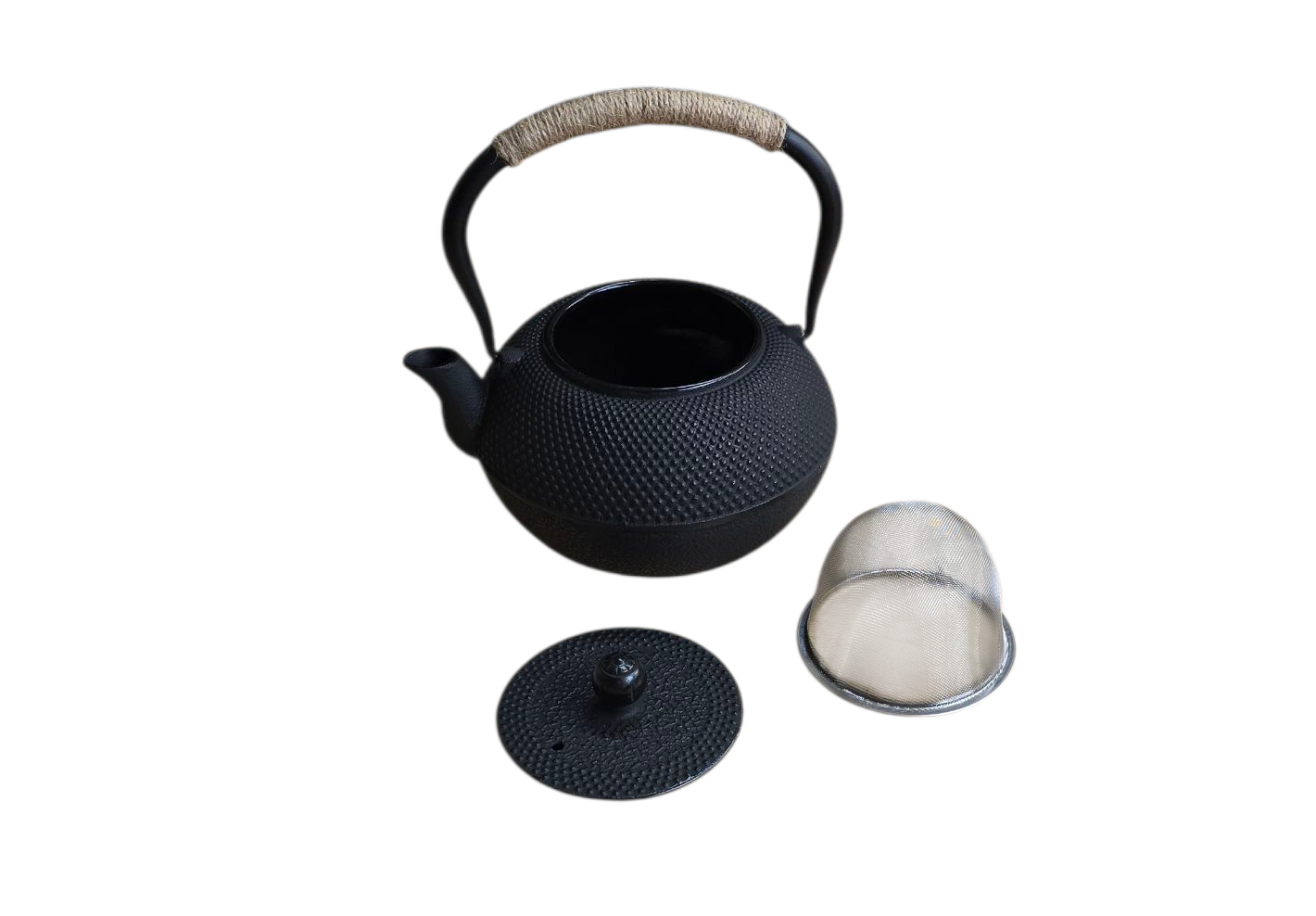Zwarte gietijzeren theepot met deksel en zeefje, witte achtergrond.