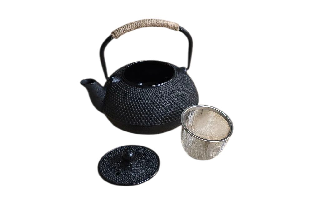 Zwarte gietijzeren theepot met deksel en zeefje, op een witte achtergrond.