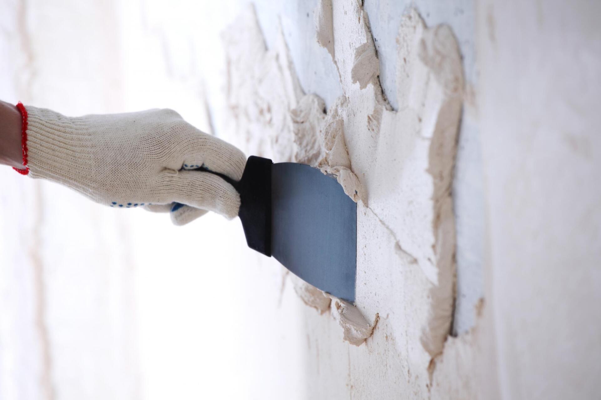 someone putting plaster on wall