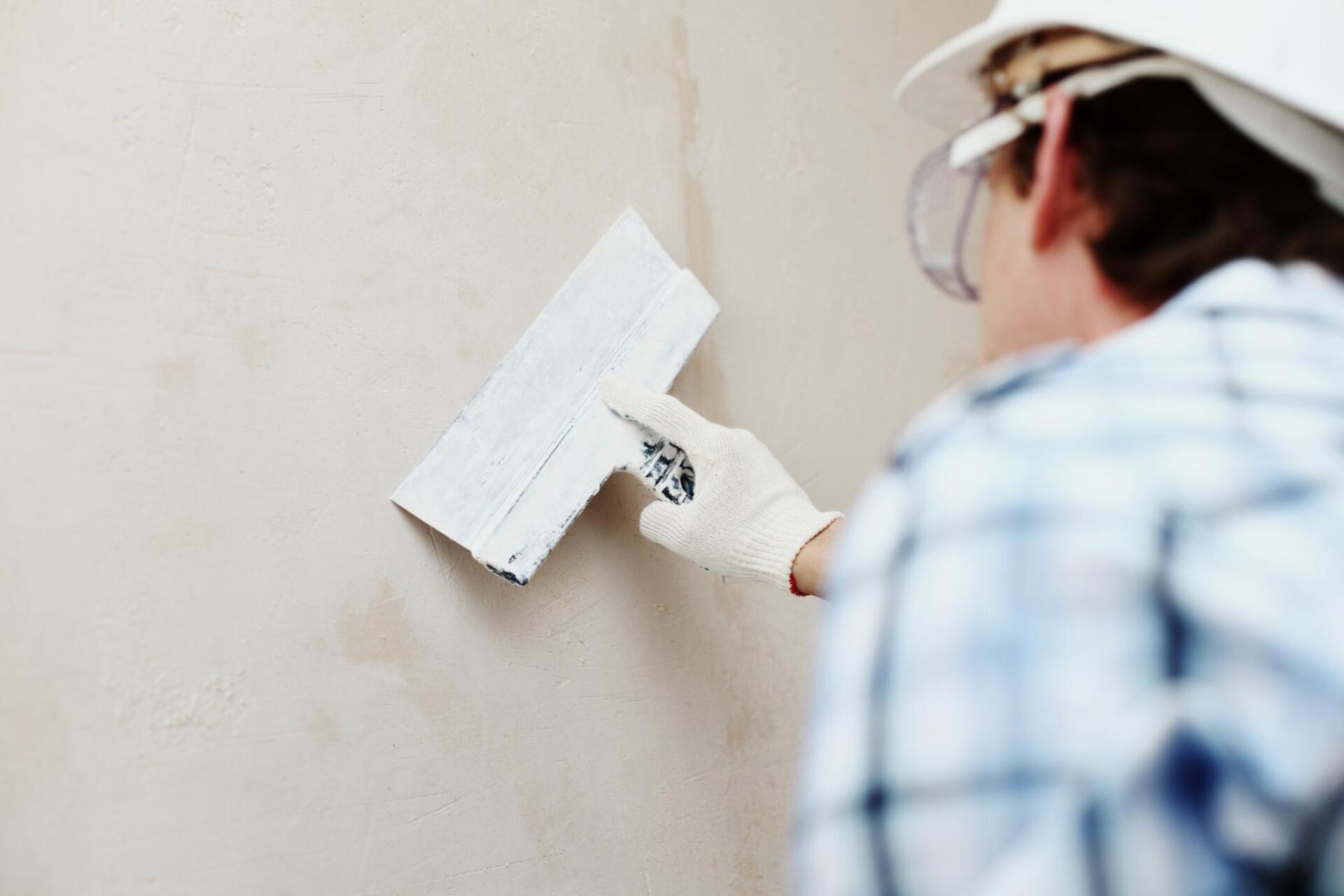 man working on an exterior stucco wall