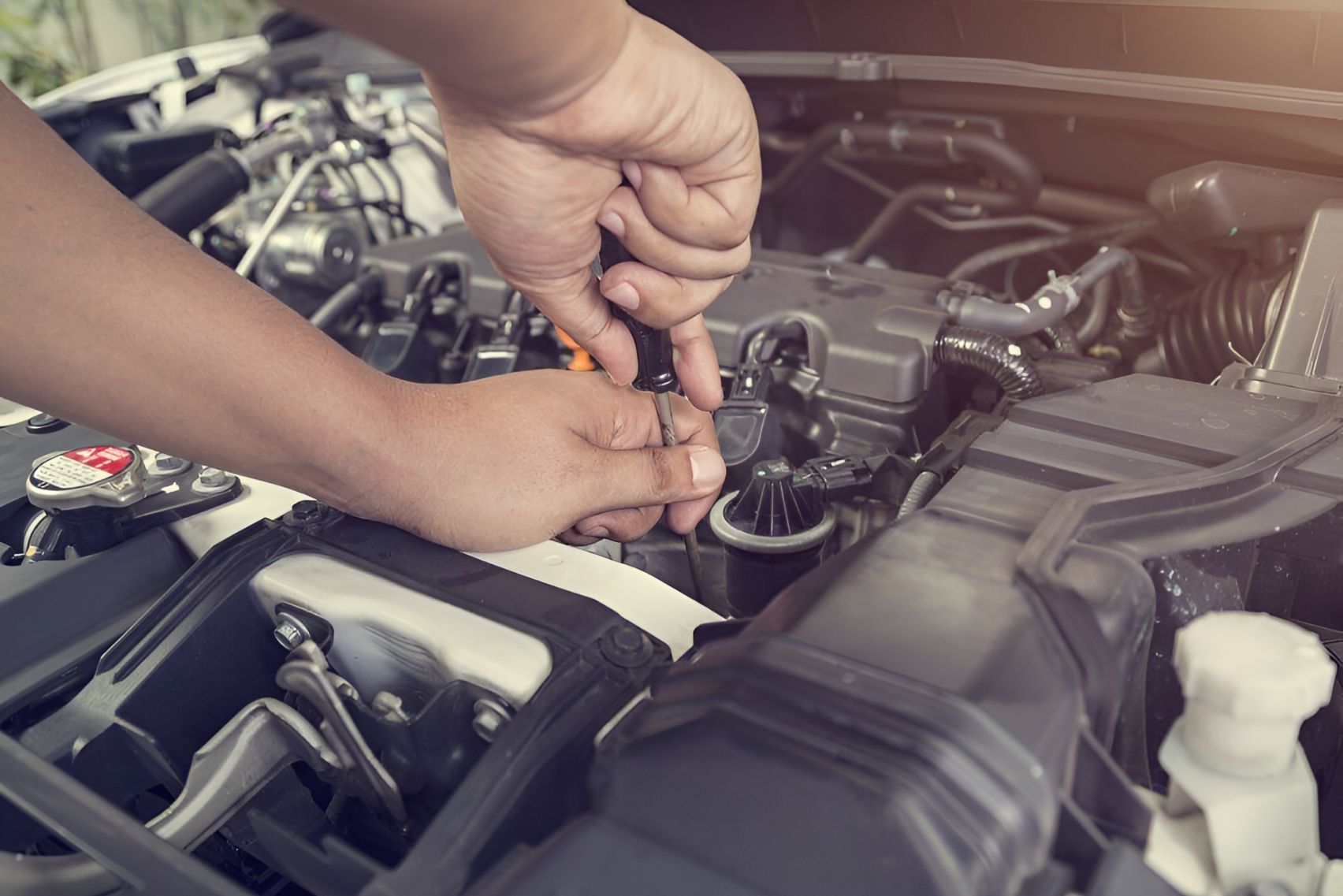 A Person is Working on the Engine of a Car With a Wrench — One Stop Service and Suspension Centre In Port Macquarie, NSW