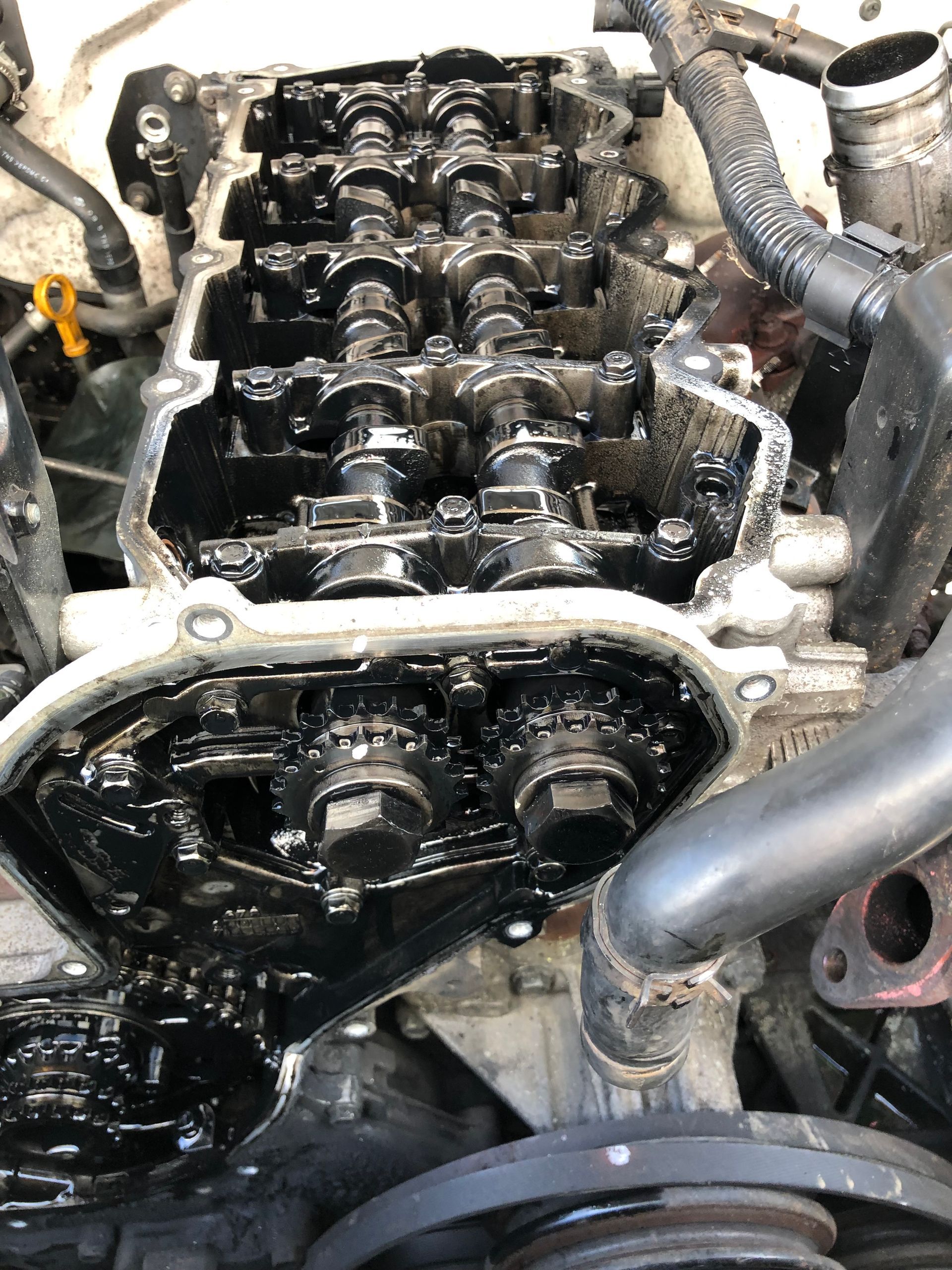 Engine with valve cover removed, revealing oily internal components.— One Stop Service and Suspension Centre In Port Macquarie, NSW