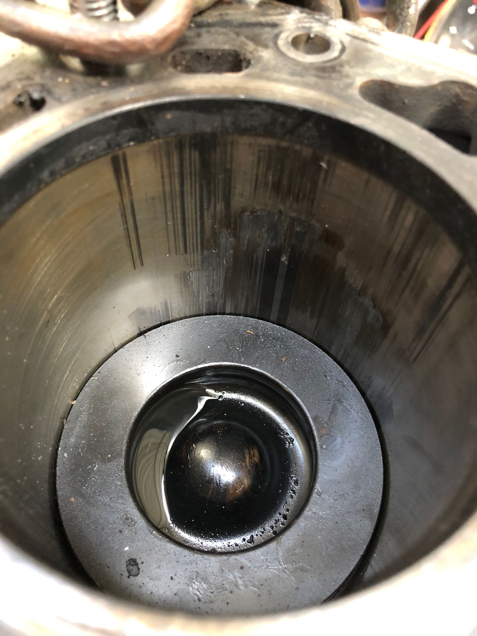 Cylinder bore with vertical scratches and a valve in the lower center, showing wear and tear.— One Stop Service and Suspension Centre In Port Macquarie, NSW