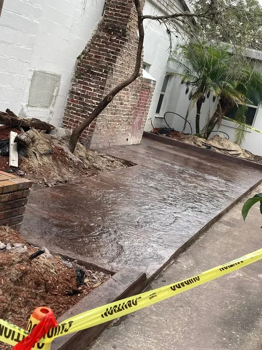 A brick wall is being demolished in front of a building