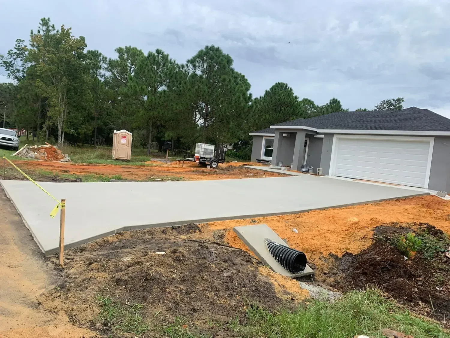 A concrete driveway is being built in front of a house.