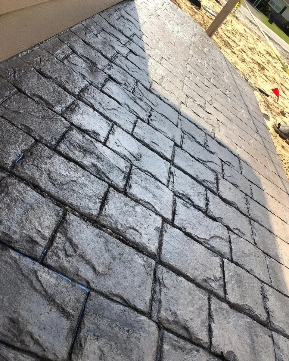 A close up of a brick walkway with a shadow on it.