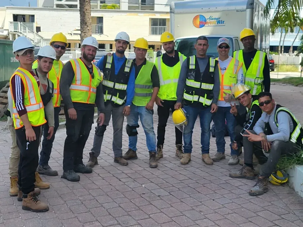 A group of construction workers are posing for a picture.