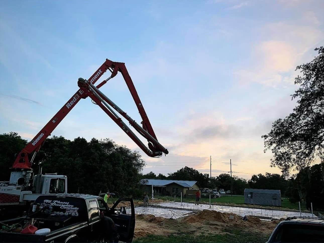 A red concrete pump is sitting in the back of a truck.