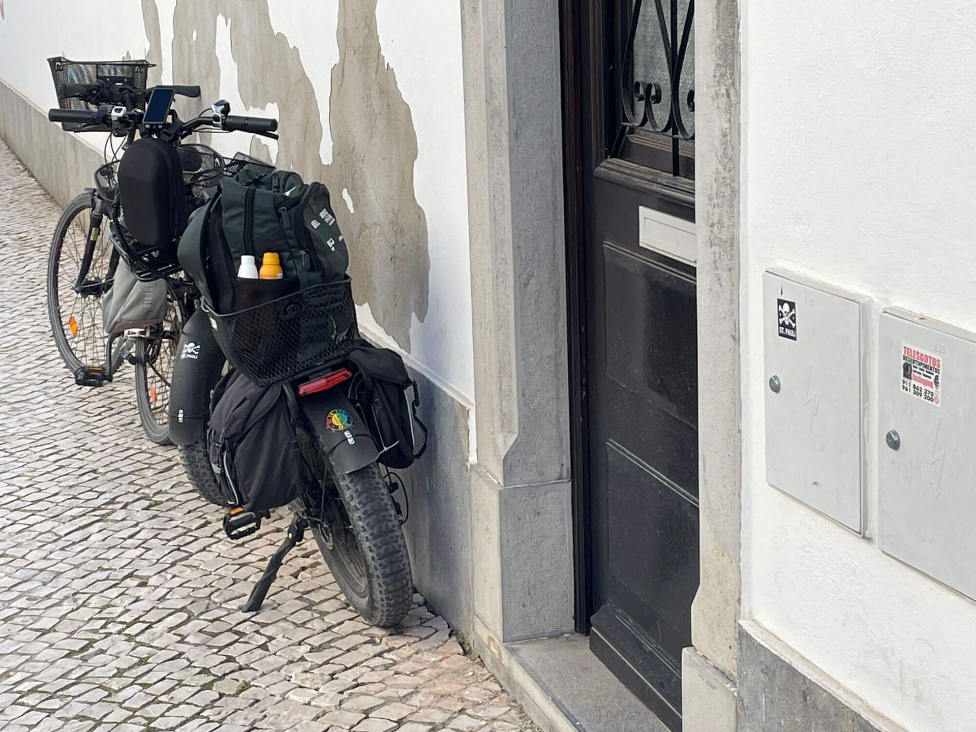 Algarve: Zwei Fahrräder stehen am Straßenrand neben einer Tür.