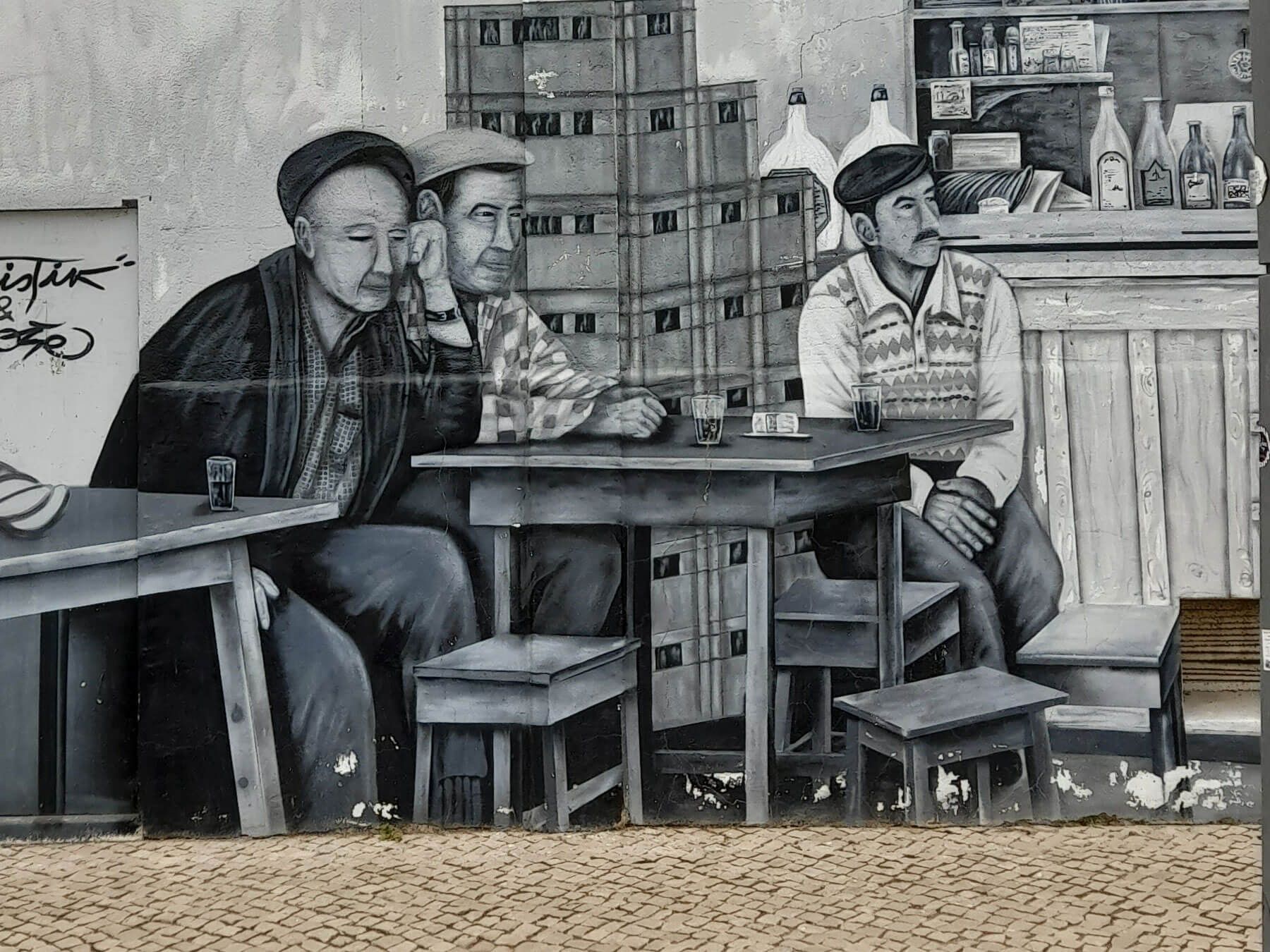 Algarve: ein Schwarzweißgemälde von drei Männern, die an Tischen sitzen