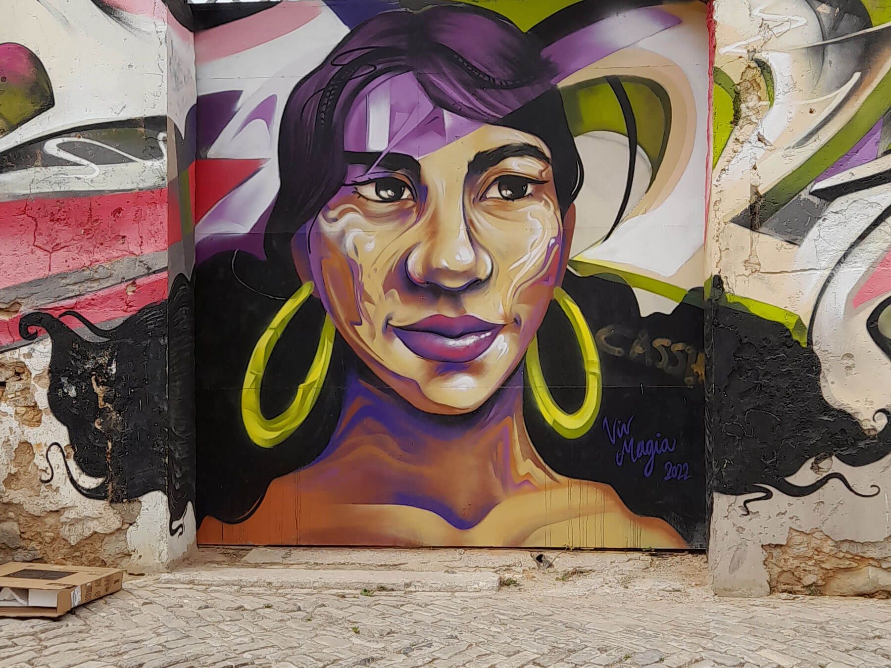 Algarve: buntes Gemälde einer Frau mit Creolen an einer Wand