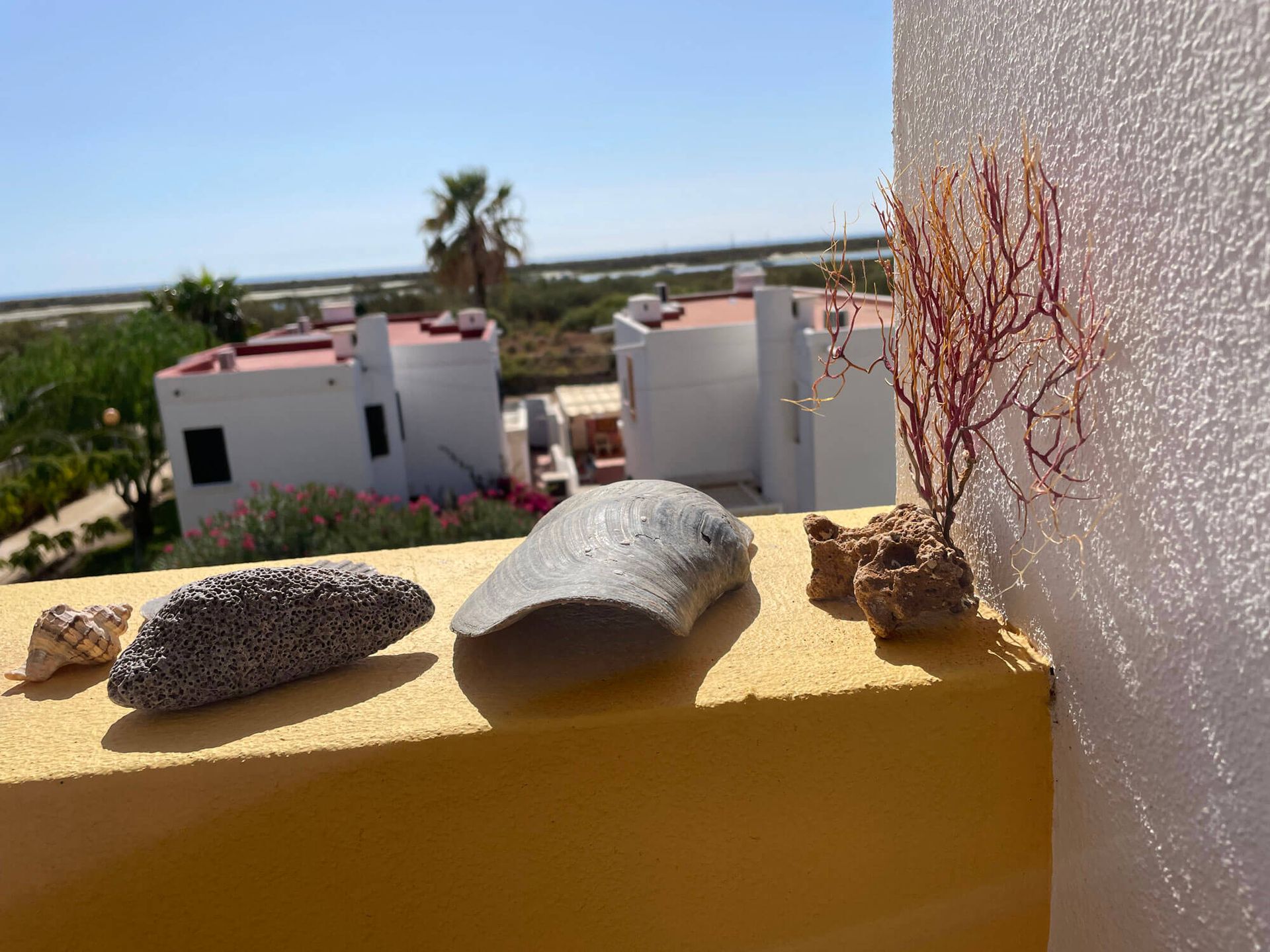 Ein Balkon mit Muscheln und Steinen darauf, Apartment Cabanas