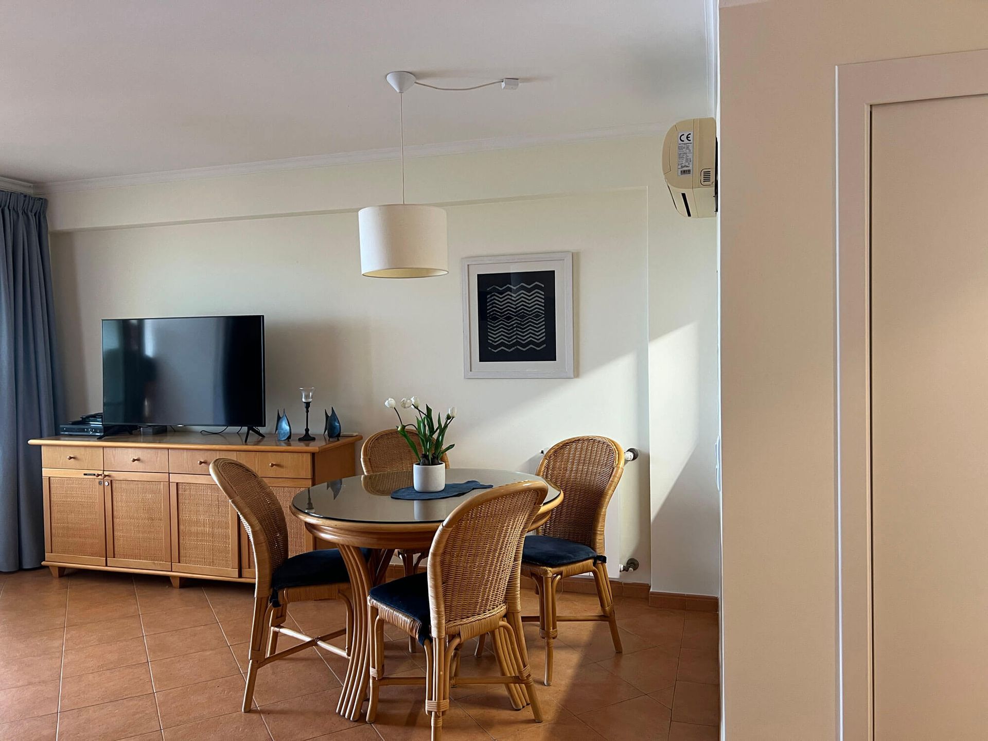 Ein Wohnzimmer mit Tisch und Stühlen und einem Flachbildfernseher, Apartment Cabanas