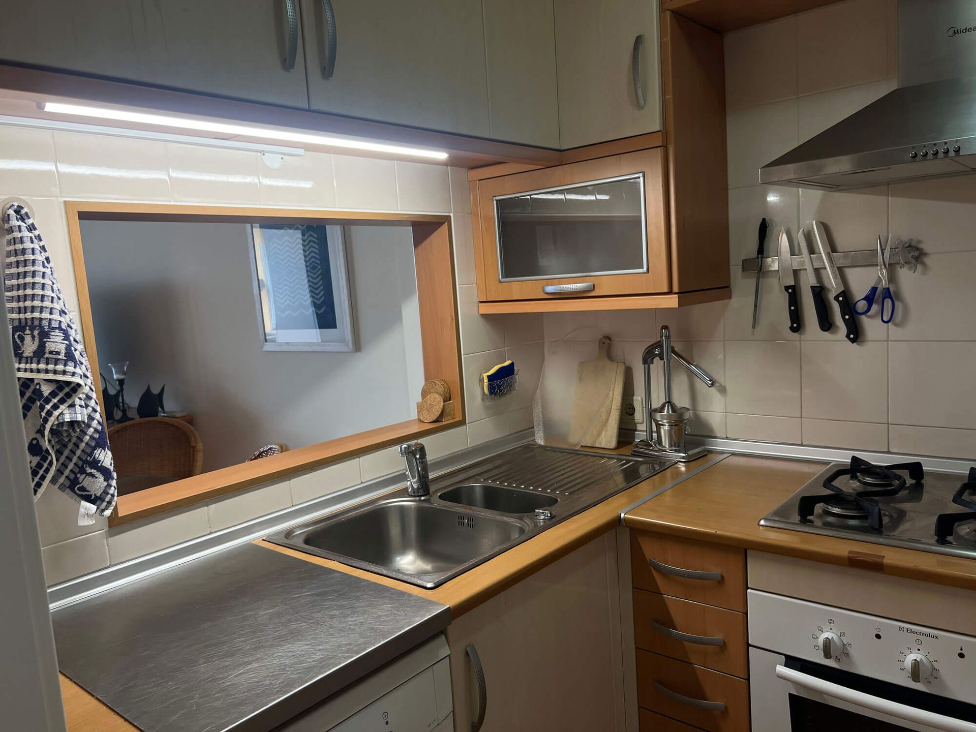 Eine Küche mit Spüle, Herd und Durchreiche, Apartment Cabanas