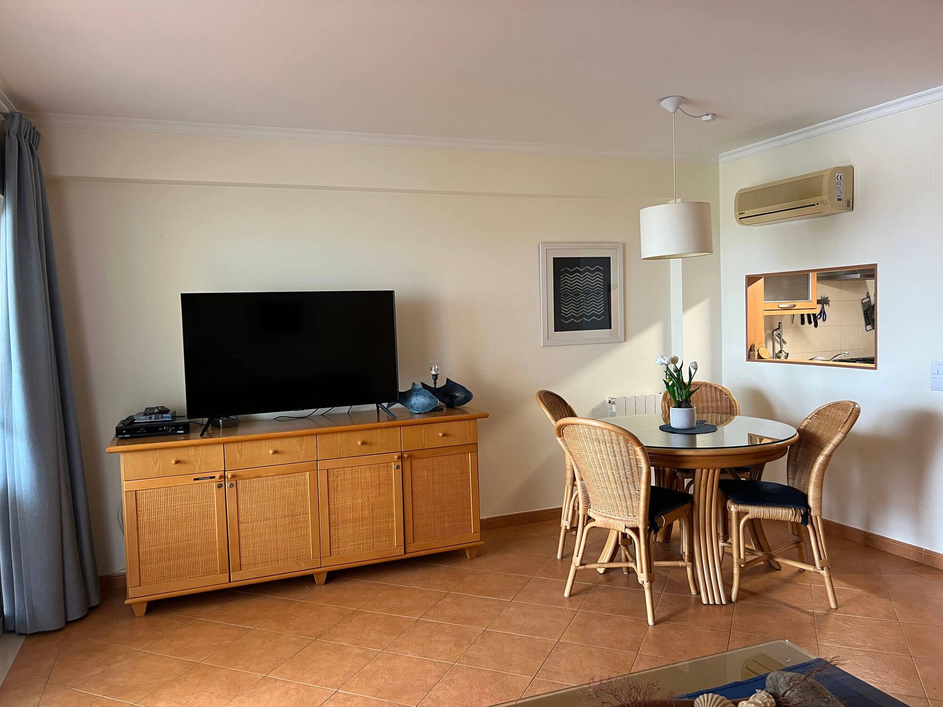 Ein Wohnzimmer mit Tisch und Stühlen und einem Flachbildfernseher, Apartment Cabanas