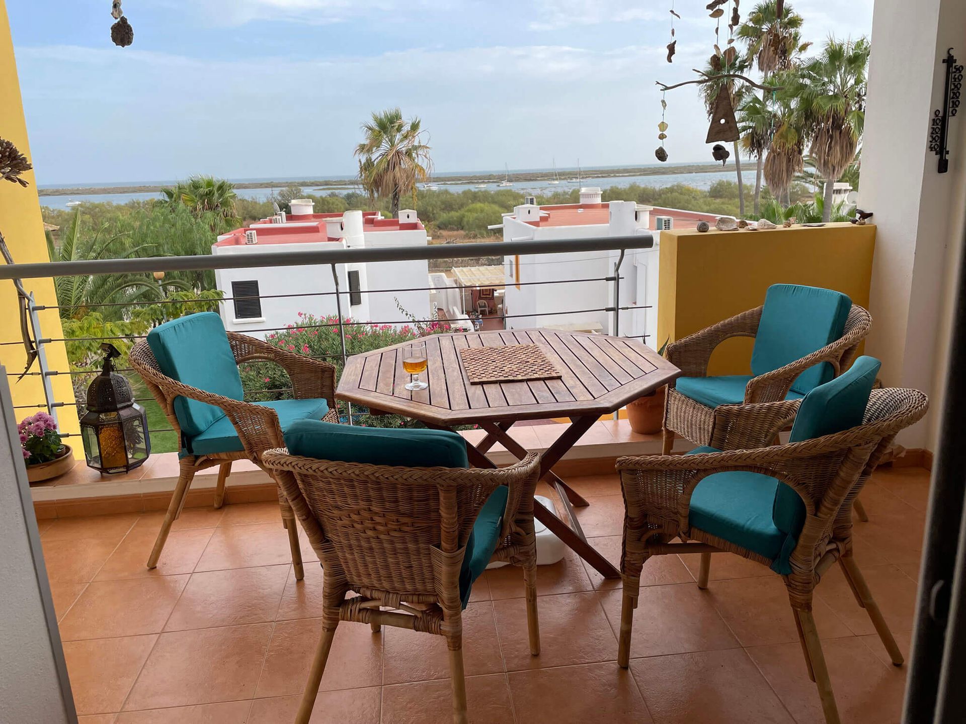 Ein Tisch und Stühle auf einem Balkon mit Blick auf das Meer