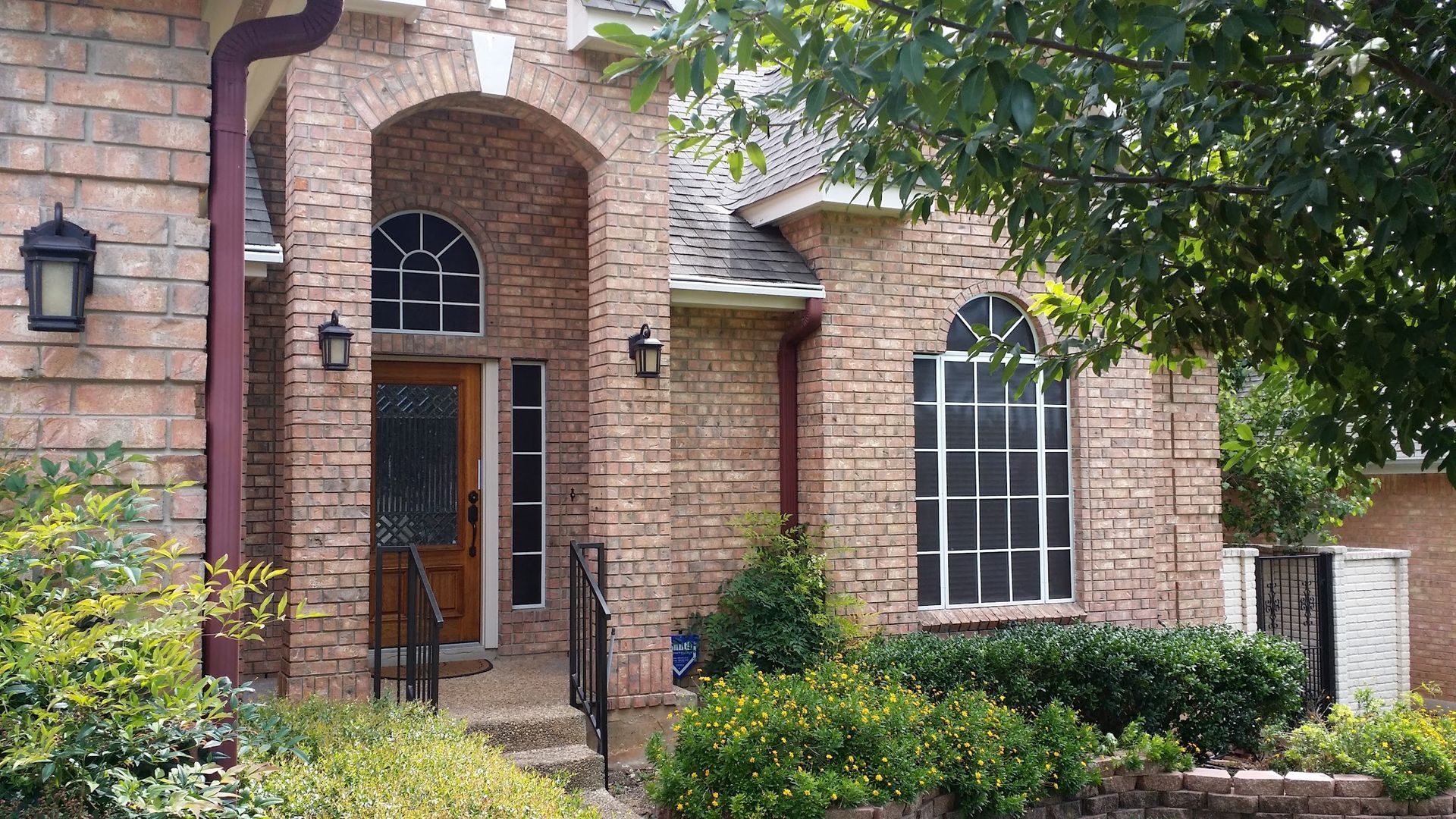 A large brick house with arched windows and a porch