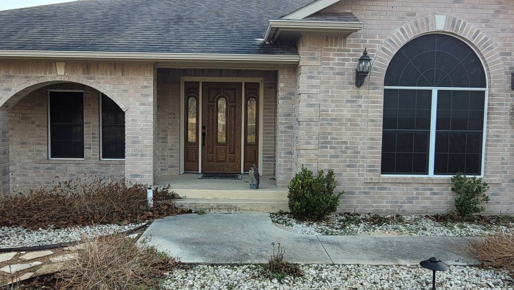 A brick house with arched windows and a screen door