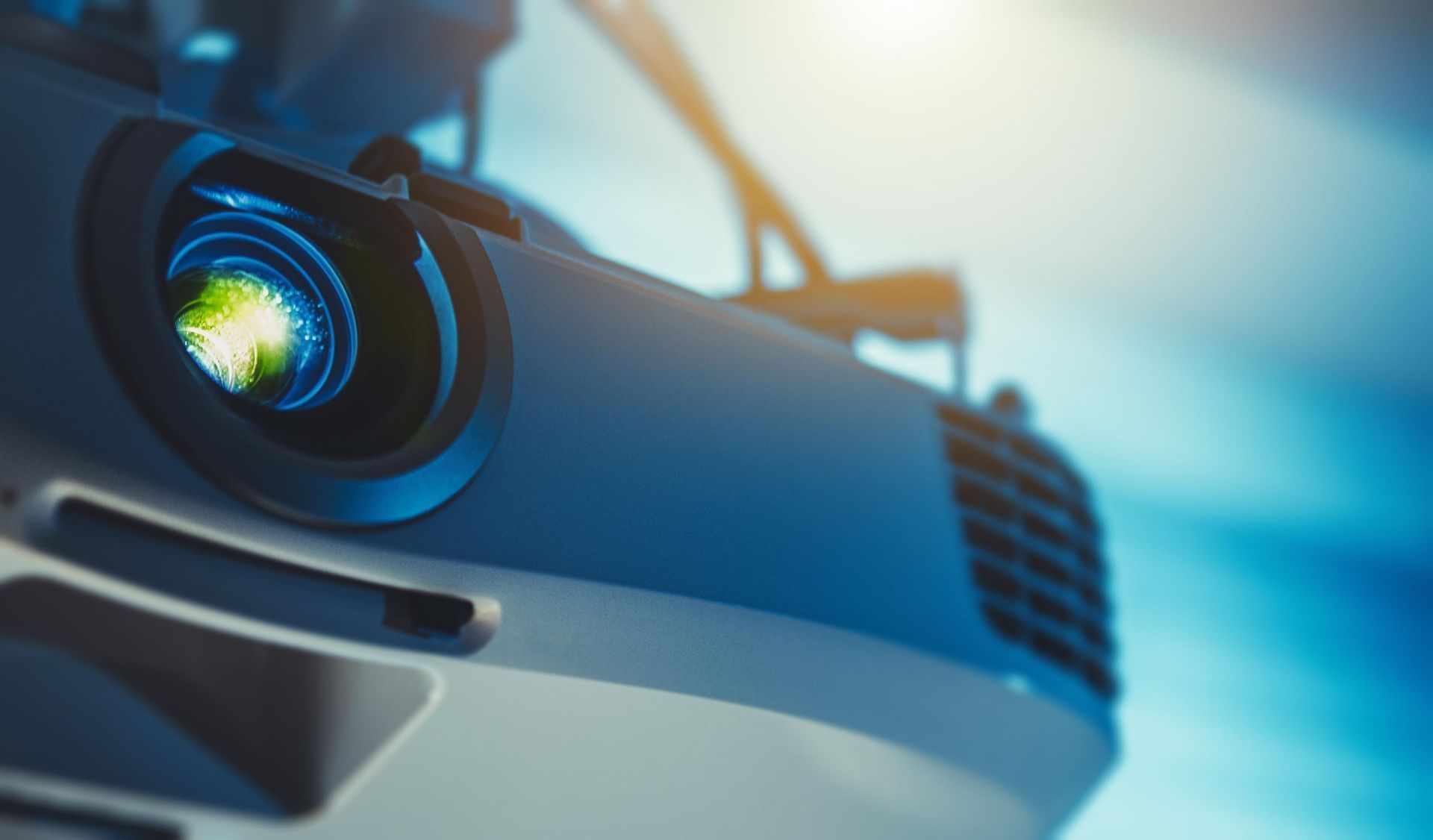 Close-up of a sleek car front with a glowing blue headlight and grille