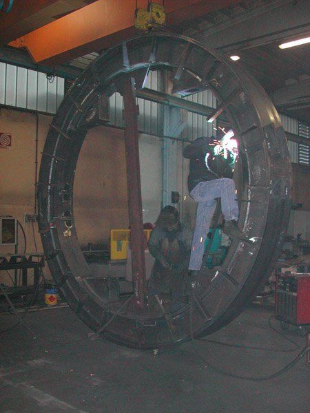 operai lavorano su un grande cerchio in ferro