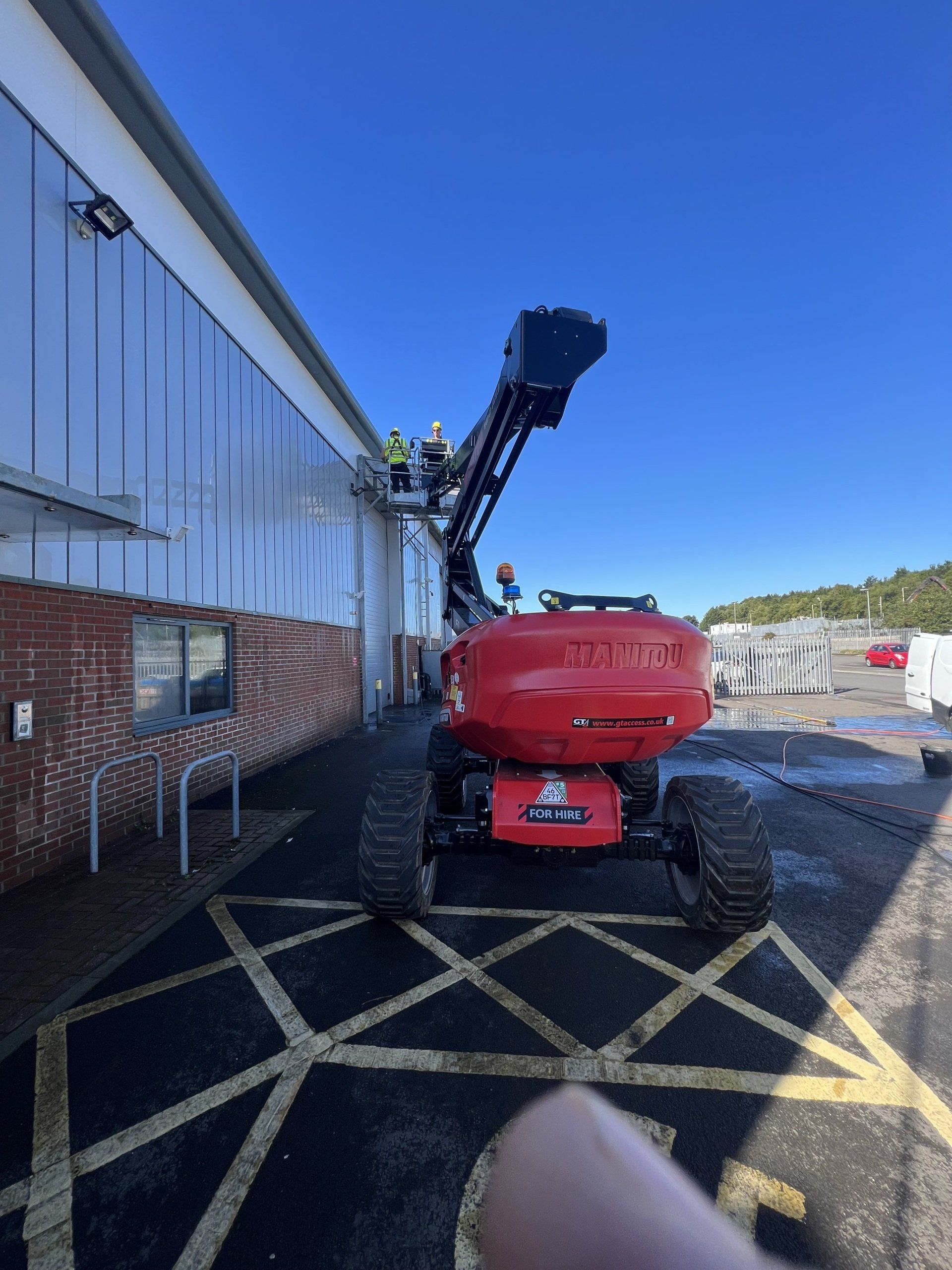Cleaner using a cherry picker to reach high windows