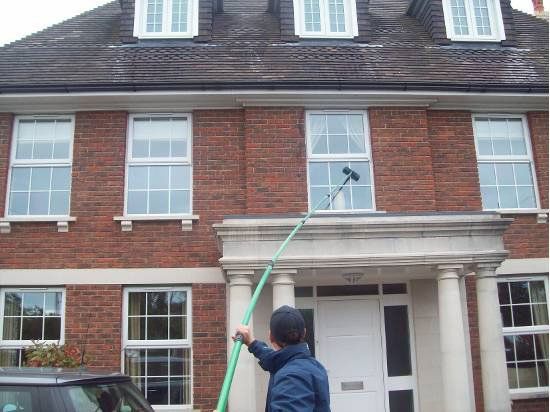 A window cleaner working on a traditional home