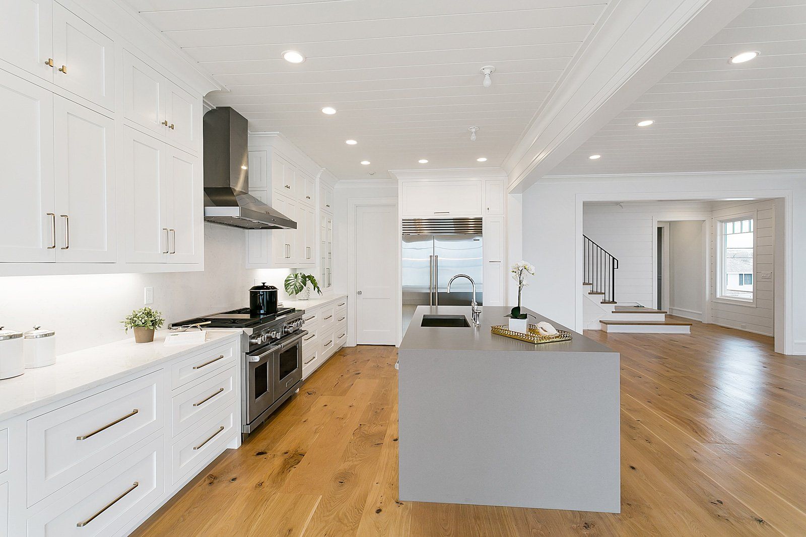 White Kitchen Cabinets, Gas Range & Waterfall Countertop | Custom Kitchen Cabinets | Domestic Kitchen Inc.
