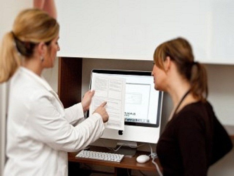 Ein Arzt und ein Patient schauen auf einen Computerbildschirm