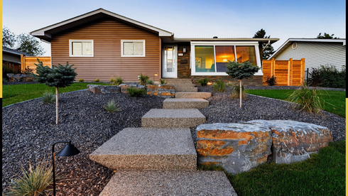 Brown house with stone steps and landscaping.