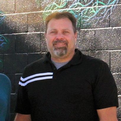 A man in a suit and tie is smiling for the camera.