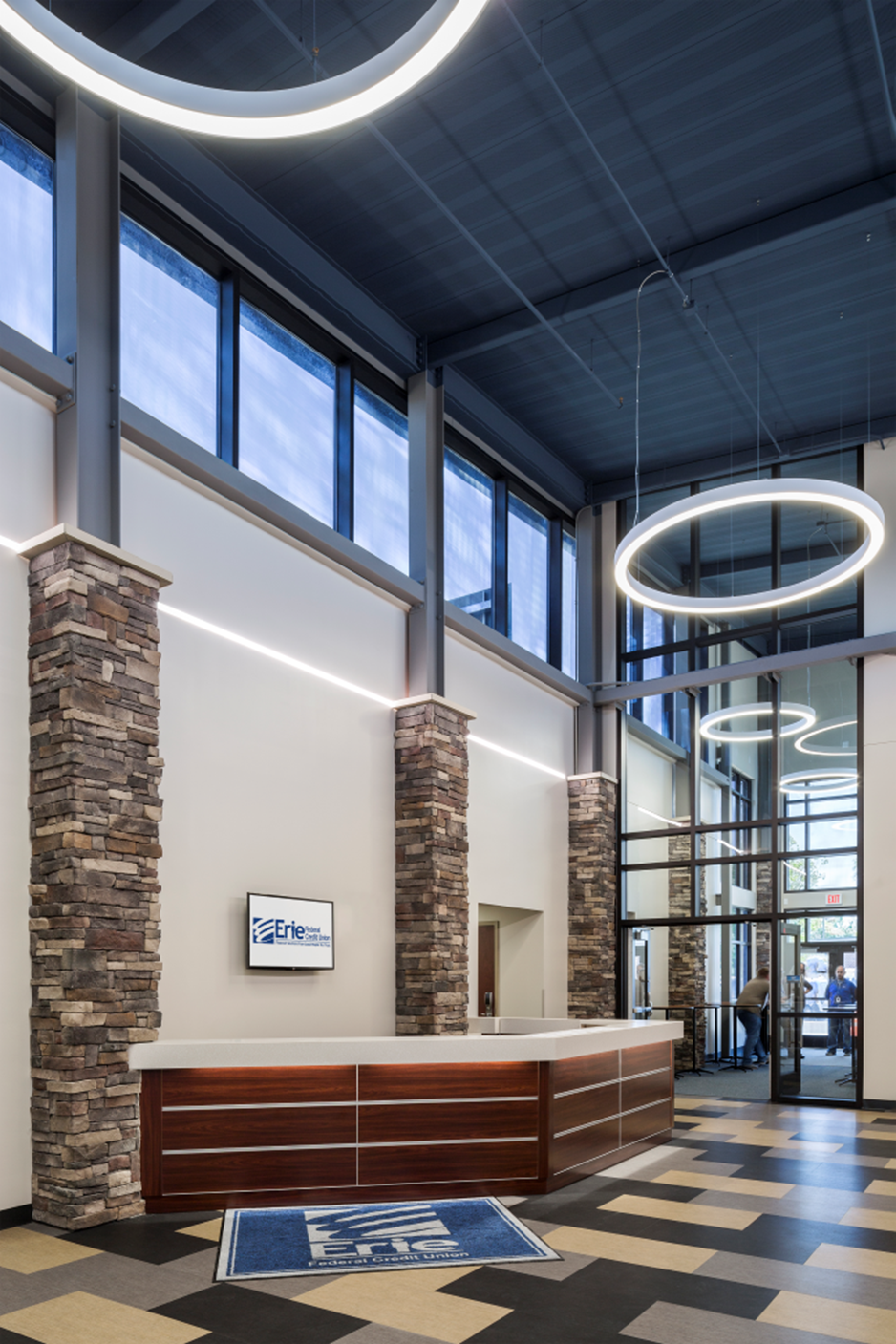 A large lobby with a reception desk and a large window
