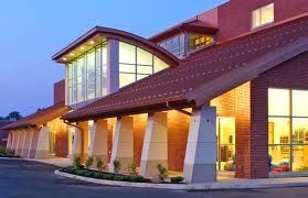 A large brick building with a bridge leading to it at night.