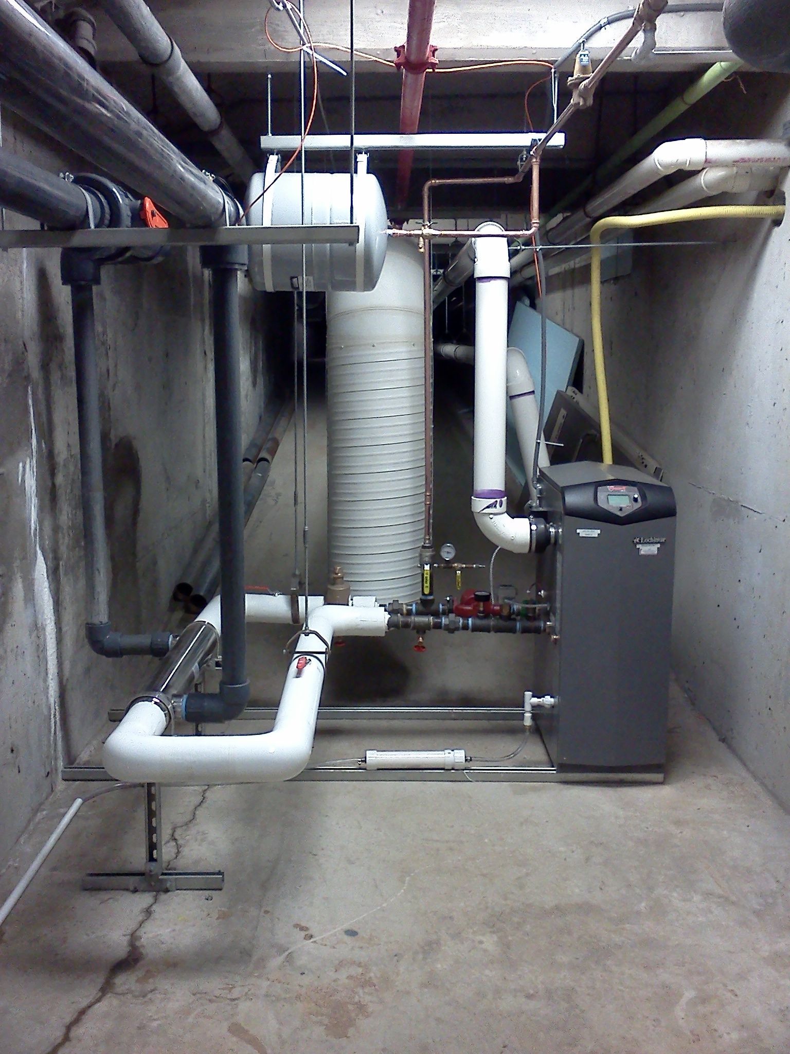 A room with pipes and a boiler in it