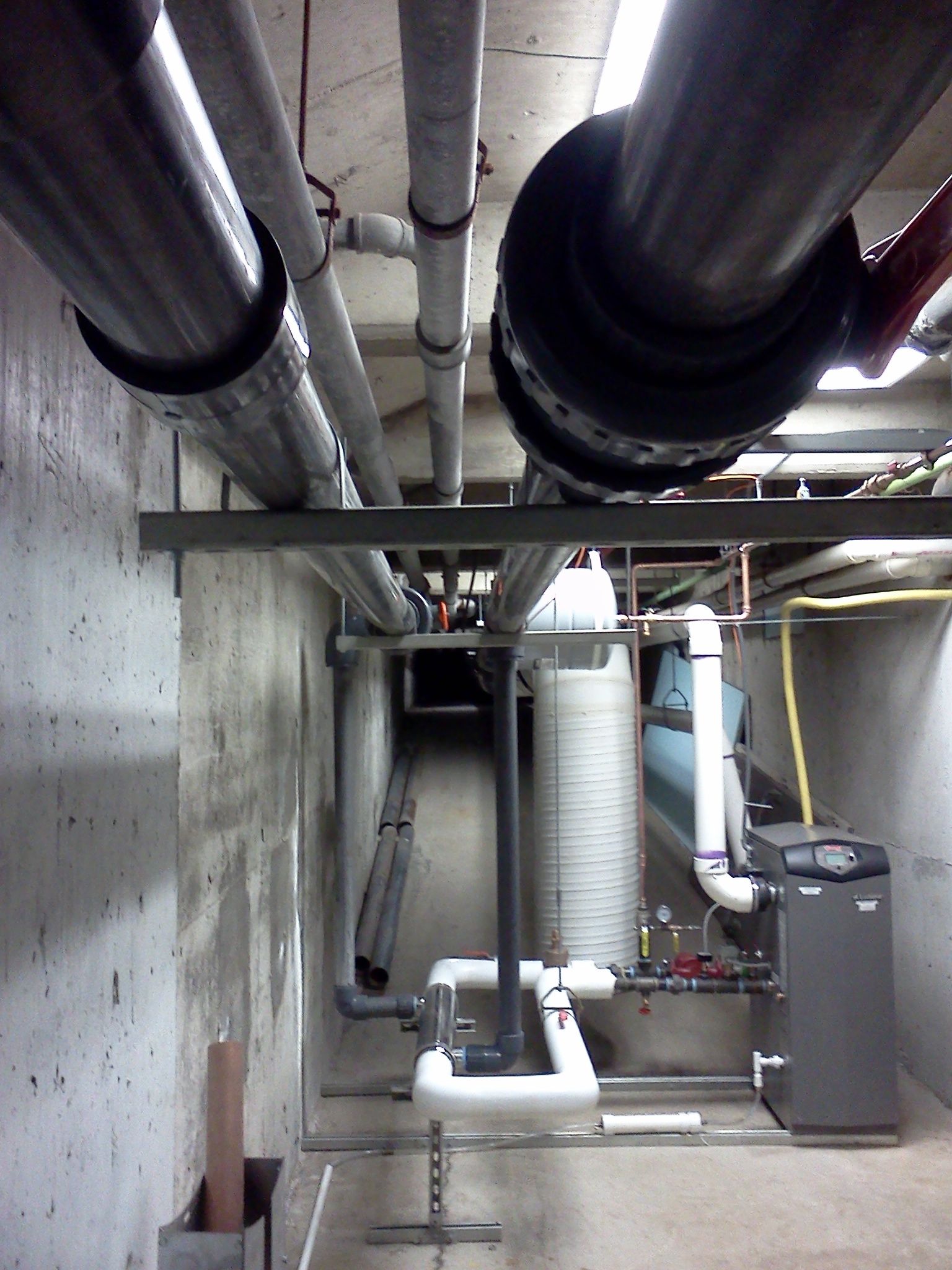 A room with a lot of pipes and a boiler