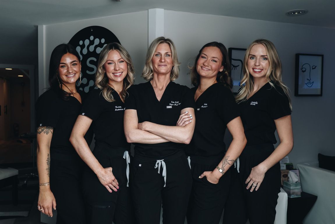A group of women in scrubs are posing for a picture.