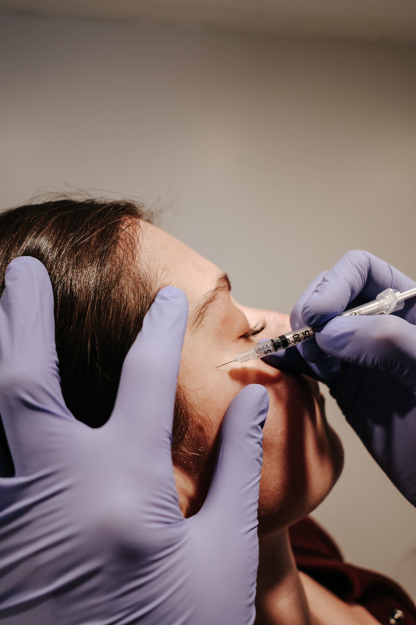 A woman is getting a botox injection in her face.