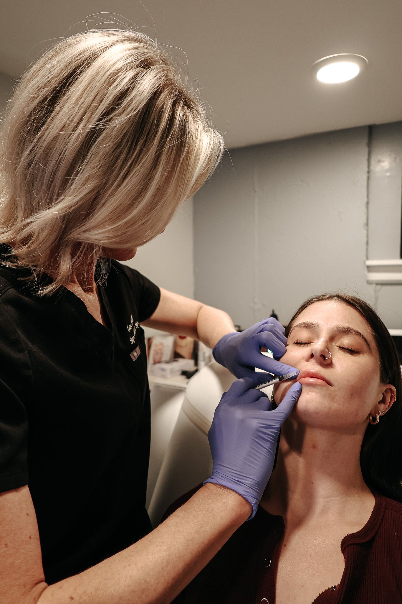 A woman is getting a botox injection in her face.
